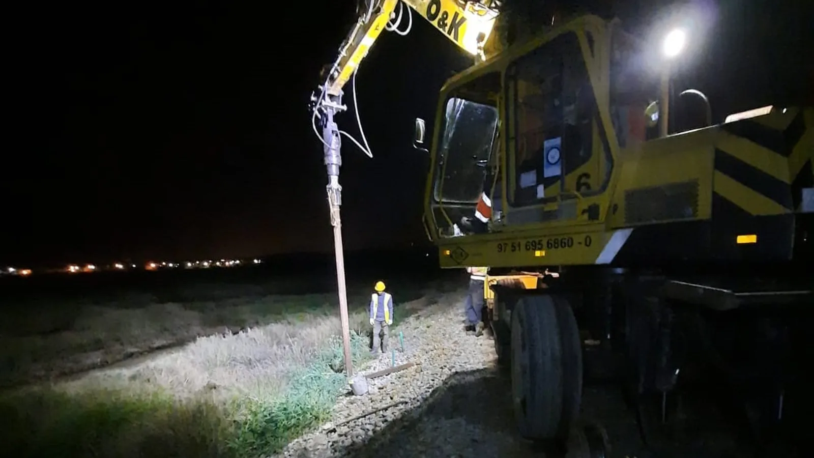 Cravação de estacas helicoidais a partir do carril, à noite, na Linha do Algarve
