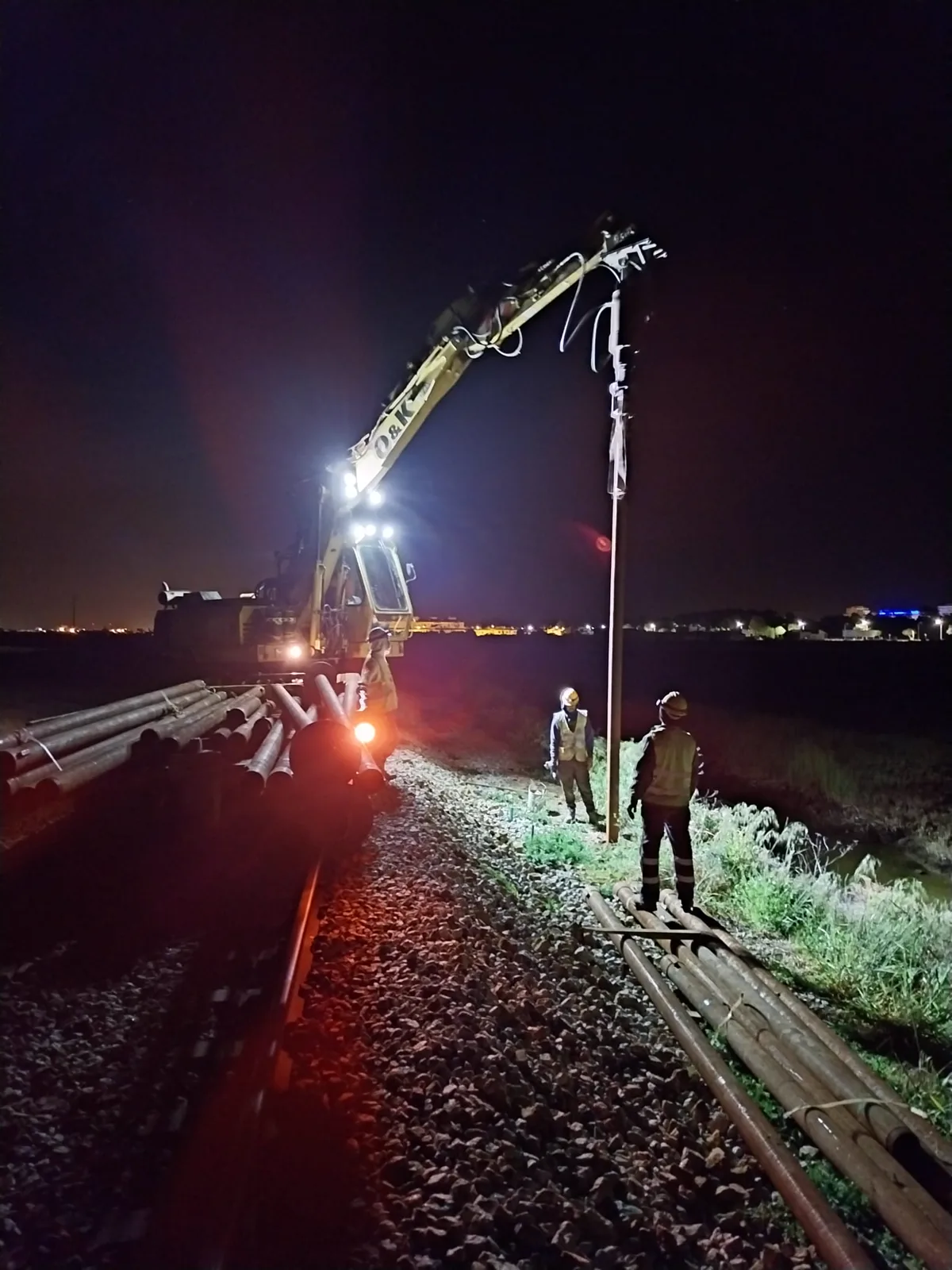 Cravação noturna de estacas helicoidais junto à via na Linha do Algarve